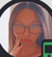 a woman wearing glasses and a green cell phone