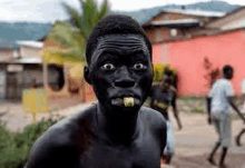 a man with his face painted black is standing in front of a building .