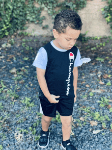 a young boy wearing a black champion shirt