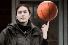 a woman is holding a basketball in her hand .