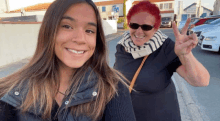 a woman with red hair giving a peace sign next to another woman