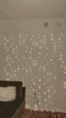 a room with a couch and a curtain of lights on the wall