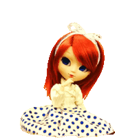 a doll with red hair and blue eyes is wearing a polka dot dress