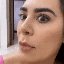 a close up of a woman 's face with mascara on her eyelashes