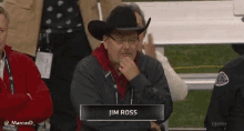 a man wearing a cowboy hat and glasses is sitting in a stadium with a name tag that says jim ross