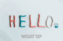 the word hello is written on a white surface with the words what up below it