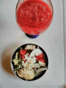 a bowl of food next to a glass of juice