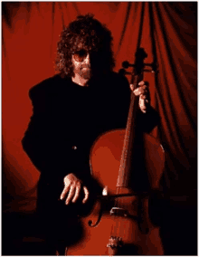 a man with curly hair is playing a cello