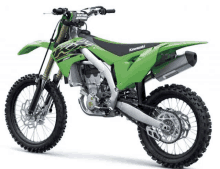 a green kawasaki dirt bike is sitting on a white background