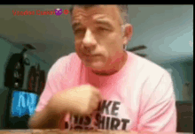 a man wearing a pink shirt that says " like a bad shirt "