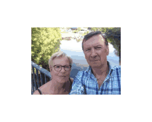 a man and woman are posing for a picture in front of a river