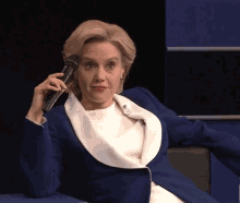 a woman in a blue jacket is talking on a phone