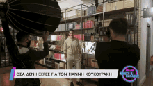 a man is being photographed in front of a wall of books and a sign that says nancy & banazhs