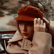 a woman wearing a red hat and a ring on her finger