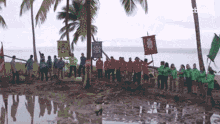 a group of people standing on a muddy beach holding flags with one that says ' sydney ' on it