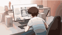 a man is sitting at a desk looking at a computer monitor