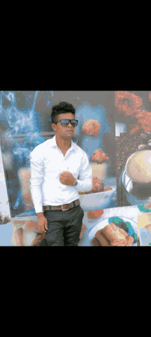 a man wearing sunglasses and a white shirt is standing in front of a wall with food pictures on it