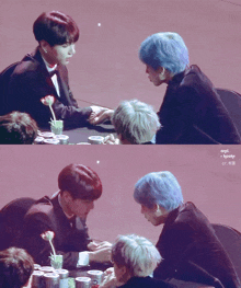 a couple of boys sitting at a table with a flower in a vase