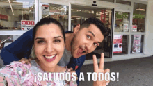 a man and a woman are posing for a picture in front of a store that has a 911 sign on it