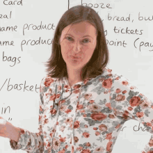 a woman in a floral shirt is standing in front of a white board with words such as bread and basket written on it