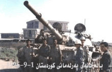 a group of soldiers are standing in front of a tank with a large cannon .