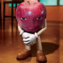 a cartoon apple with arms and legs is sitting on the floor