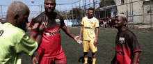 a group of soccer players are standing on a field and one of them is wearing a shirt that says ' regret '