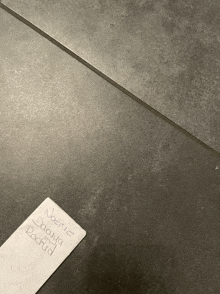 a piece of paper on a tile floor that says ' nazirc daura rockrid ' on it