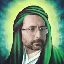 a man with glasses and a beard wearing a green turban and a green robe .