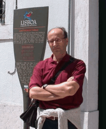 a man is standing in front of a sign that says lisboa .