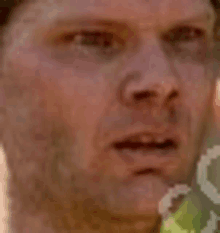 a close up of a man 's face with a hat on and a blurred background .