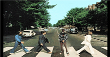 a group of people walking across a crosswalk with a white car in the background