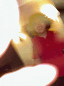 a blurry picture of a person 's face with a red shirt on