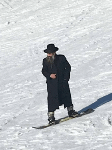 a man in a black coat and hat is skiing down a snowy slope