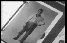 a man is standing in a black and white photo .