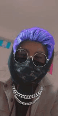 a person with purple hair and sunglasses is wearing a mask and a chain around their neck .