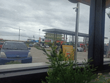 a blue prius is parked in front of a yellow sign that says everyday