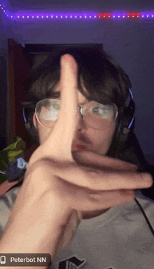 a person wearing glasses and headphones is making a peace sign with their finger