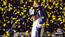 a man in a blue and white jacket is surrounded by yellow confetti and stars .