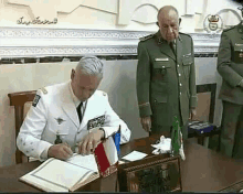 a man in a white uniform is signing a guestbook at a table