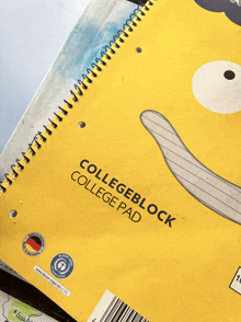 a yellow collegeblock college pad with a bear face on it