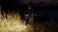 a soldier is kneeling down in the dark with a gun