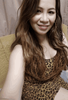 a woman wearing a leopard print top is smiling for the camera