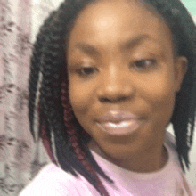 a close up of a woman 's face wearing a pink shirt .