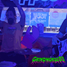 a man playing a guitar in front of a screen that says grindhorse93