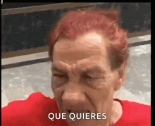 an elderly woman with red hair is making a funny face and saying que quieres .