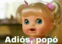 a close up of a baby doll with the words `` adiós , popó '' written next to it .