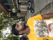 a man wearing a yellow t-shirt with a picture of a man on it