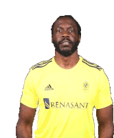 a man wearing a yellow adidas shirt with renasant on the front