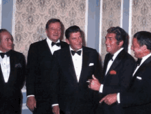 a group of men in tuxedos and bow ties are standing next to each other